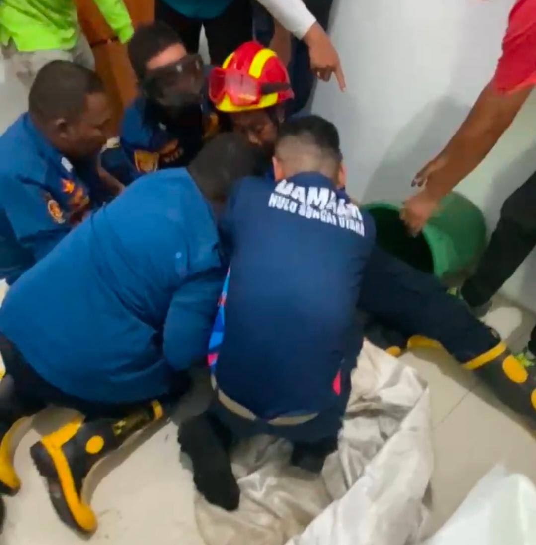 EVAKUASI: Petugas Damkar HSU berupaya mengevakuasi seekor beruk (bangkuy) yang terjebak di dalam toilet Kantor Diskuperindag HSU, Jumat (27/3/2026).