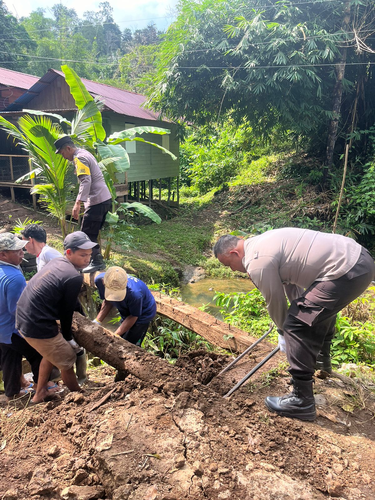 CEK LOKASI:Kapolres HST, AKBP Jupri JHP Tampubolon ditemani warga dan perangkat desa meninjau lokasi jembatan Sungai Harag yang roboh beberapa waktu lalu.