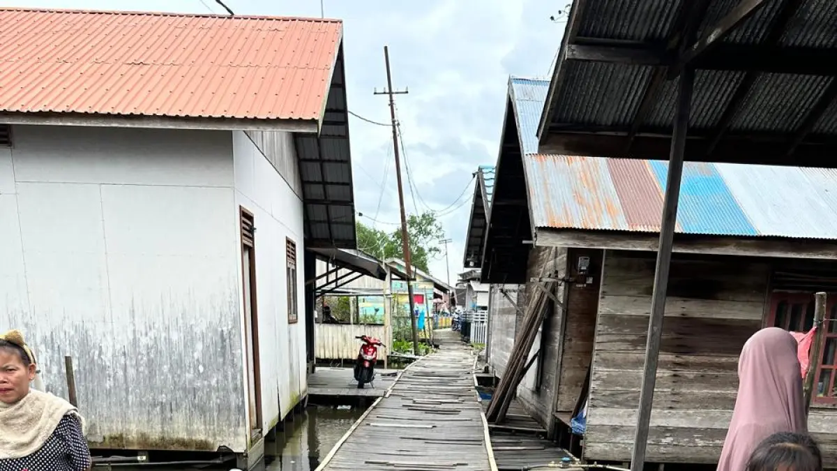 MASUK POKIR: Warga melintasi titian kayu yang rusak di Kelurahan Murung Selong, Banjarmasin Timur.