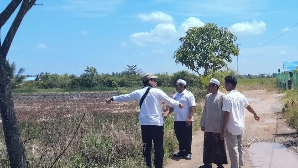 MONITORING : Petugas DPUPRP Kabupaten Banjar bersama pihak kecamatan dan desa meninjau lokasi genangan air di lahan pertanian Kecamatan Tatah Makmur. (DINAS PUPRP KABUPATEN BANJAR)