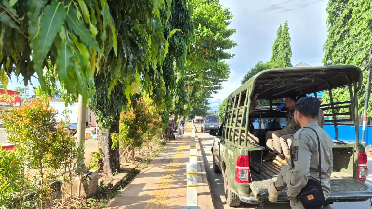 PERSUASIF : Personil Satpol PP dan Damkar Tala saat melakukan komunikasi dengan para PKL agar mau pindah berjualan ke area parkir RTH Hasan Bari. (Foto : Norsalim Yahya/Radar Banjarmasin)