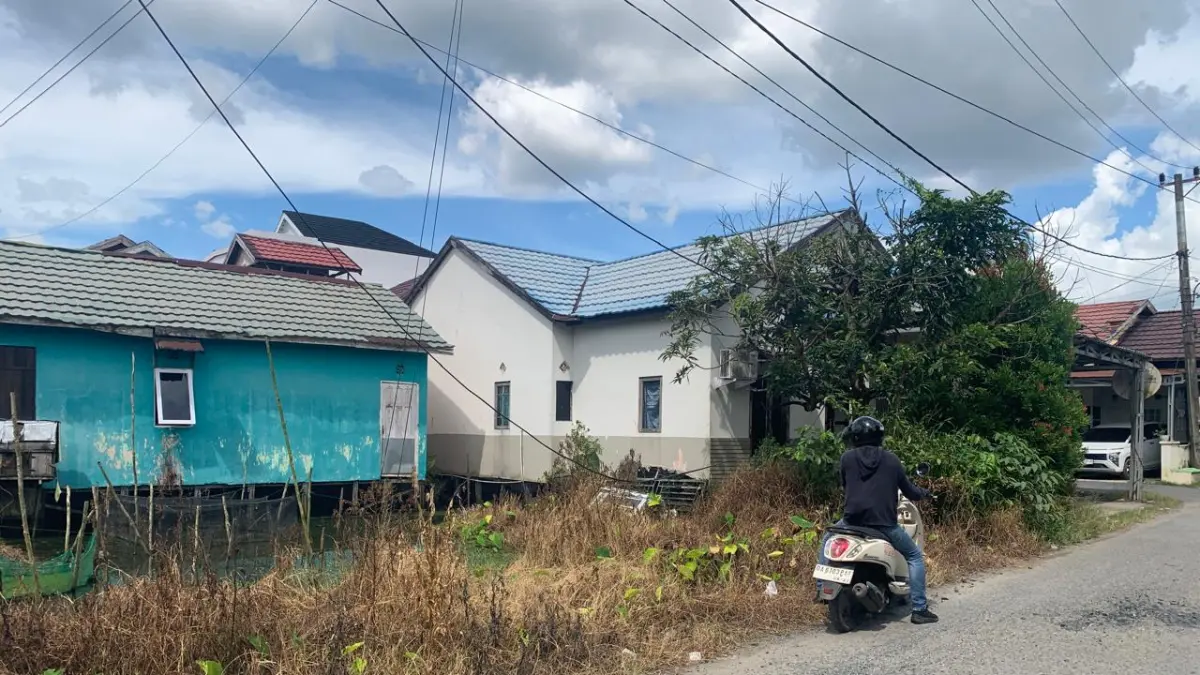 Warga RT 27 HKSN, Kelurahan Alalak Utara, mengeluhkan kabel optik yang menjuntai tidak hanya menggangu pemandangan tetapi juga membahayakan.(Foto: Endang Syarifuddin/Radar Banjarmasin)