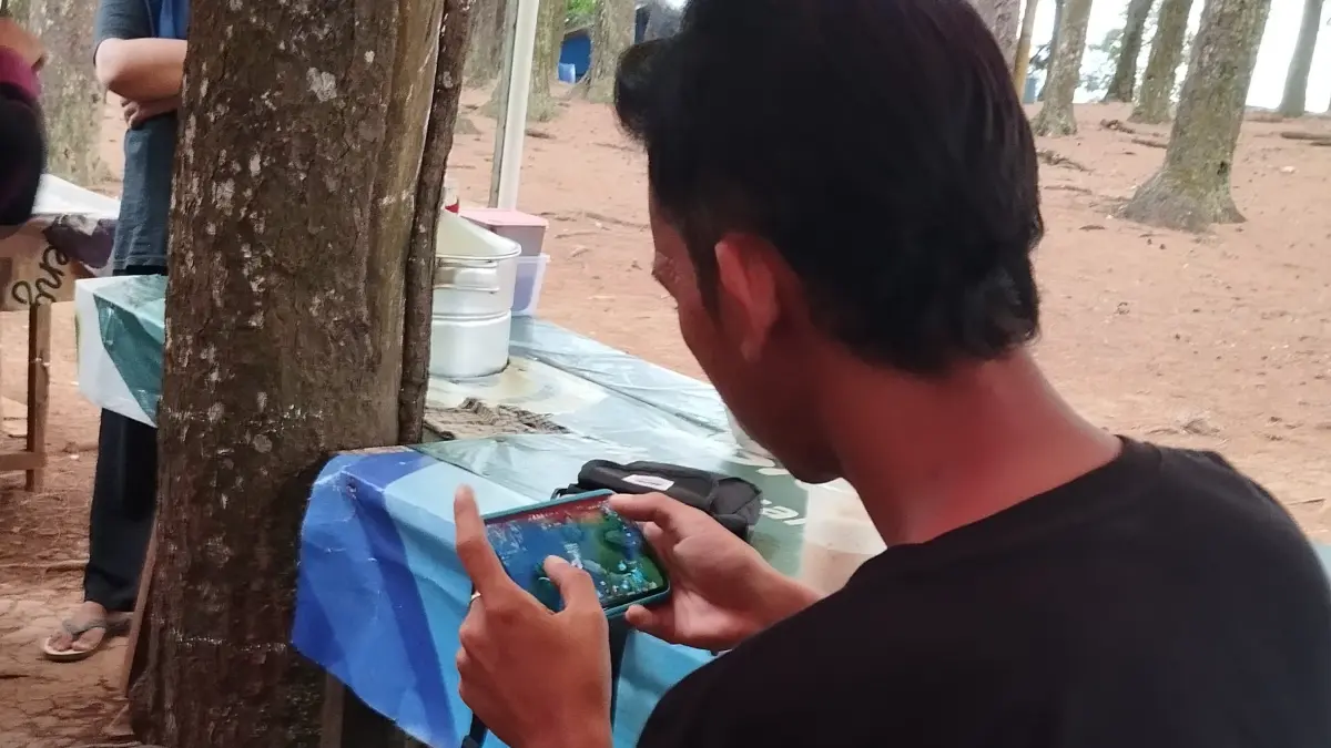 Salah satu warga Kalimantan Selatan mengakses internet melalui gawainya untuk bermain game online. Aktivitas digital meningkat, namun belum sepenuhnya berdampak pada ekonomi masyarakat. (FADLAN ZAKIRI/RADAR BANJARMASIN)