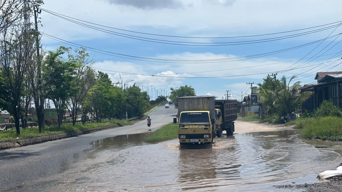 Genangan air di Jalan Gubernur Soebardjo, Banjarmasin Selatan tak kunjung surut dan kerap menyebabkan pengendara motor terjatuh karena terdapat jalan yang rusak di baliknya.(Zulvan Rahmatan/Radar Banjarmasin)