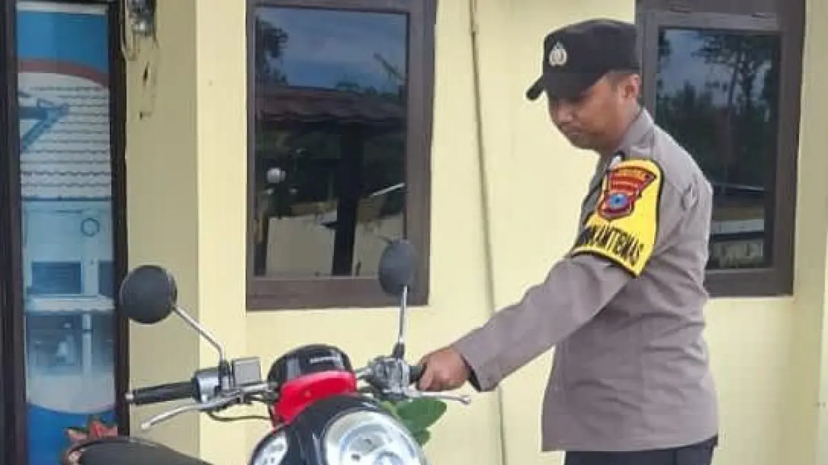 TAK BERTUAN:Bhabinkamtibmas Kelurahan Mabuun Polres Tabalong, Bripka Eddy Kurniawan mengevakuasi motor matic Honda Scoopy yang tersimpan selama tiga hari di semak-semak dan tidak diketahui pemiliknya.(Foto:Polres Tabalong)