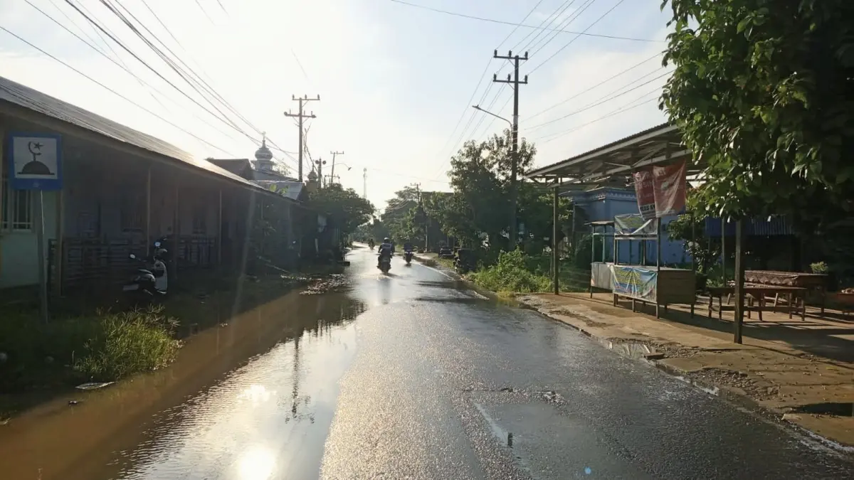 MELUAP: Kondisi air Sungai Balangan di Kecamatan Banjang Kabupaten HSU, meluap hingga menggenangi badan jalan di Desa Kaludan Kecil, Kecamatan Banjang, Minggu (12/4/2026).