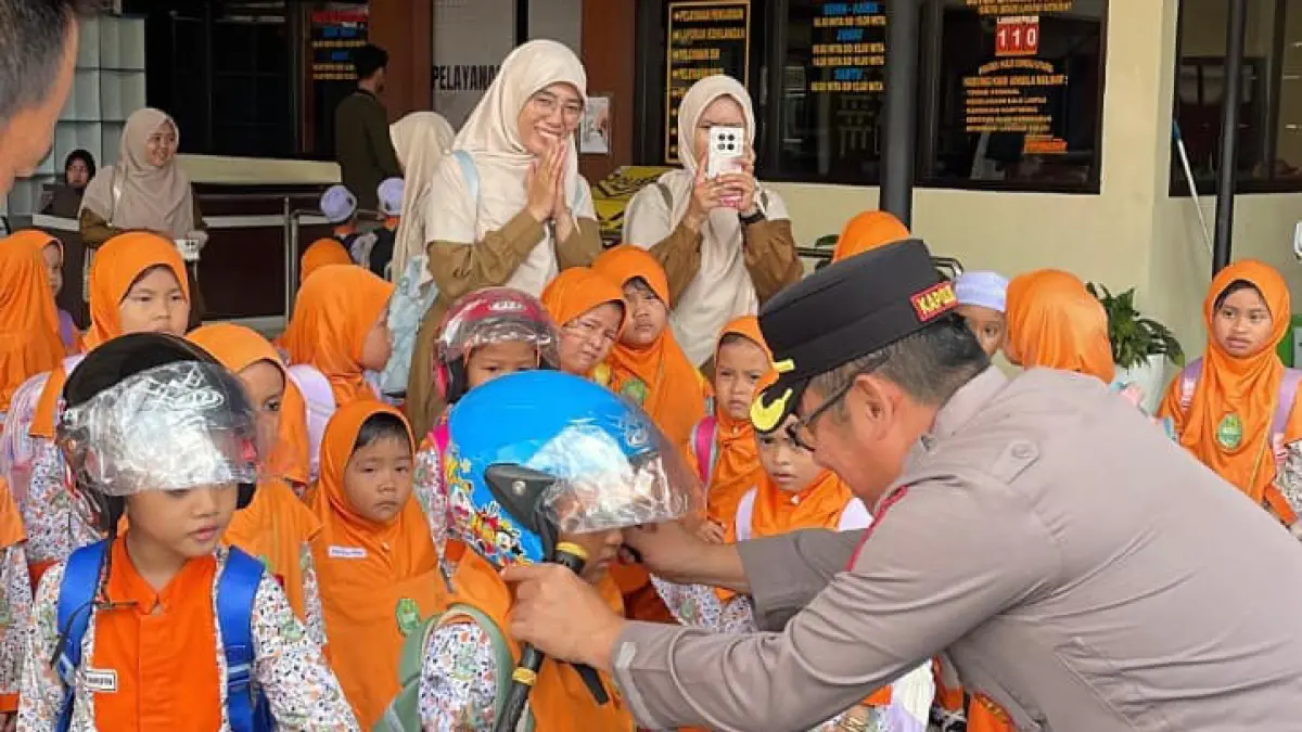PASANG HELM: Kapolres HSU AKBP Agus Nuryanto didampingi personel Sat Lantas memberikan edukasi keselamatan berlalu lintas kepada anak-anak dalam kegiatan Polisi Sahabat Anak di Mapolres HSU.
