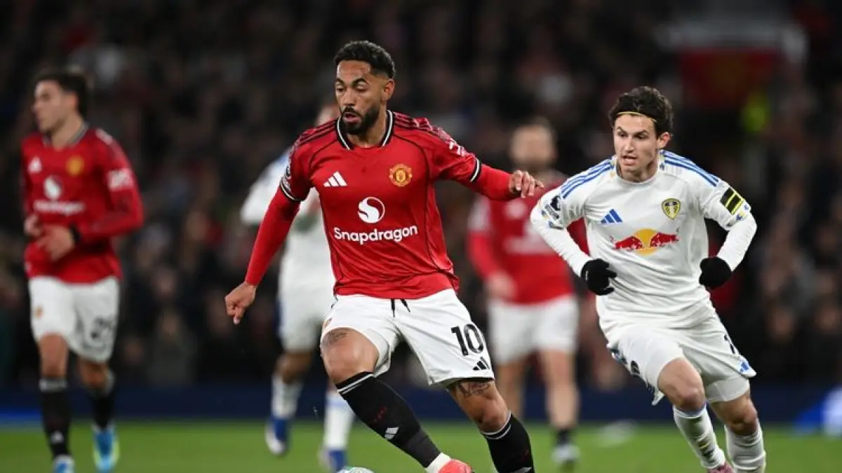 BERLARI: Pemain Manchester United, Matheus Cunha berlari dengan bola dalam pertandingan sepak bola Liga Inggris melawan Leeds United di Old Trafford, Selasa (14/4).&nbsp;
(AFP/PAUL ELLIS)