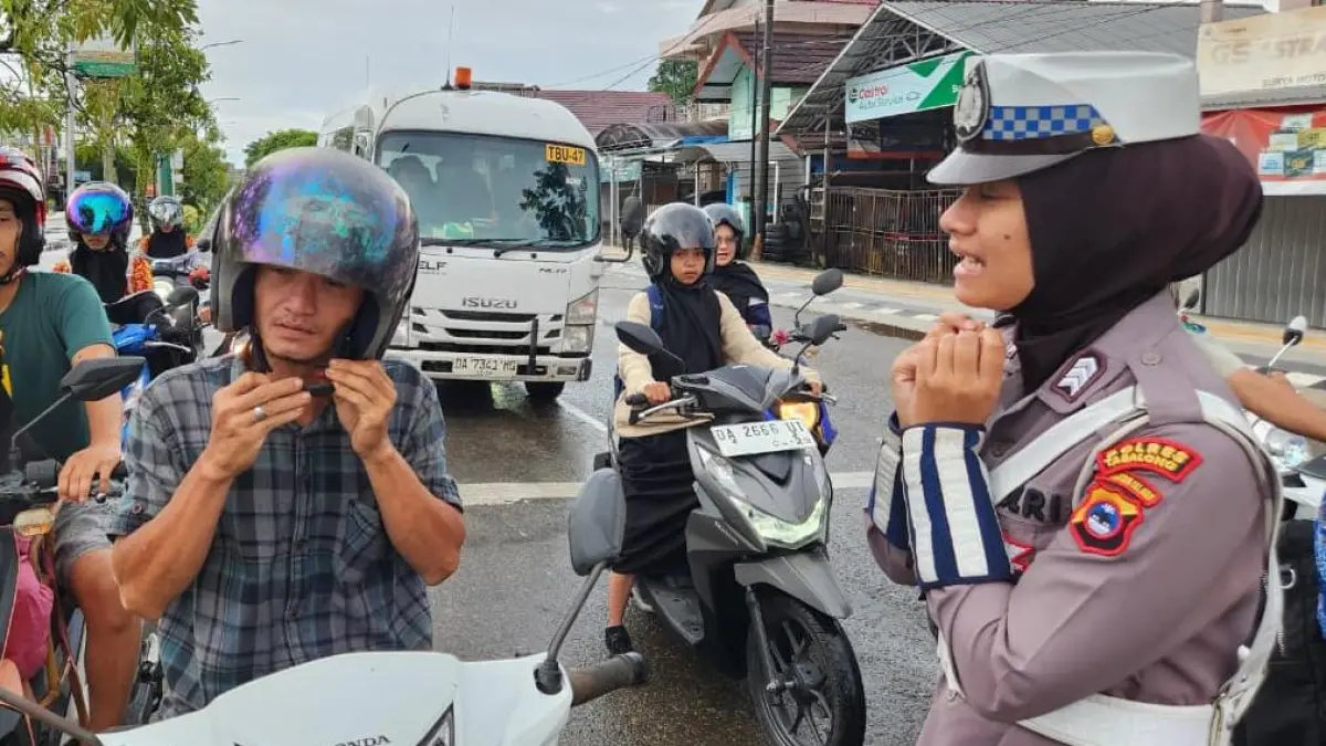 DITEGUR: Pengendara sepeda motor ditegur karena tidak mengklik tali helmnya saat berkendara. (Foto : Polres Tabalong untuk Radar Banjarmasin)