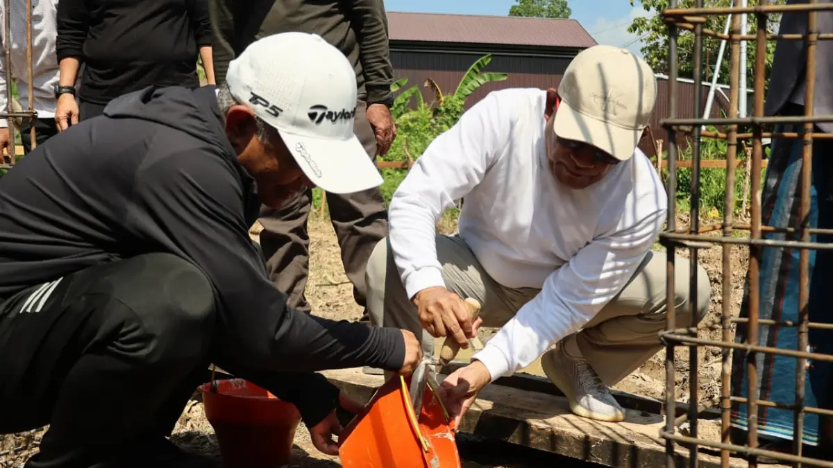 MOMEN:Bupati HSU, Sahrujani bersama H Muhammad Azhari melakukan peletakan batu pertama pembangunan Langgar Al-Azhari di Desa Banyu Tajun Hilir, disaksikan sejumlah pejabat daerah dan tokoh masyarakat. (Foto:Pemkab HSU)