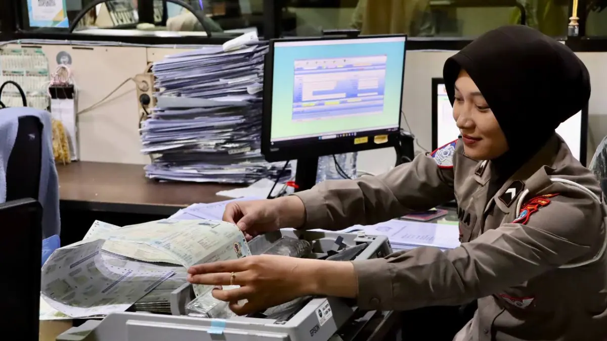 Petugas kepolisian mencetak Surat Tanda Nomor Kendaraan (STNK) lima tahun di Layanan Samsat Induk Kantor UPTD Samsat Banjarbaru. (uppd samsat banjarbaru)
