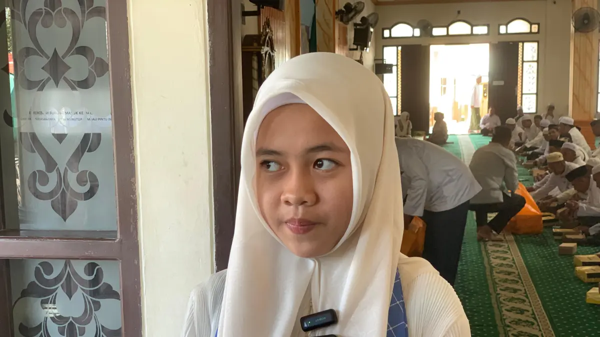 Sofia Kamila (13), jemaah calon haji termuda asal Kabupaten Banjar, saat wawancara usai mengikuti pelepasan di Masjid Nurul Iman, Sabtu (18/04/2026). (FADLAN ZAKIRI/RADAR BANJARMASIN)