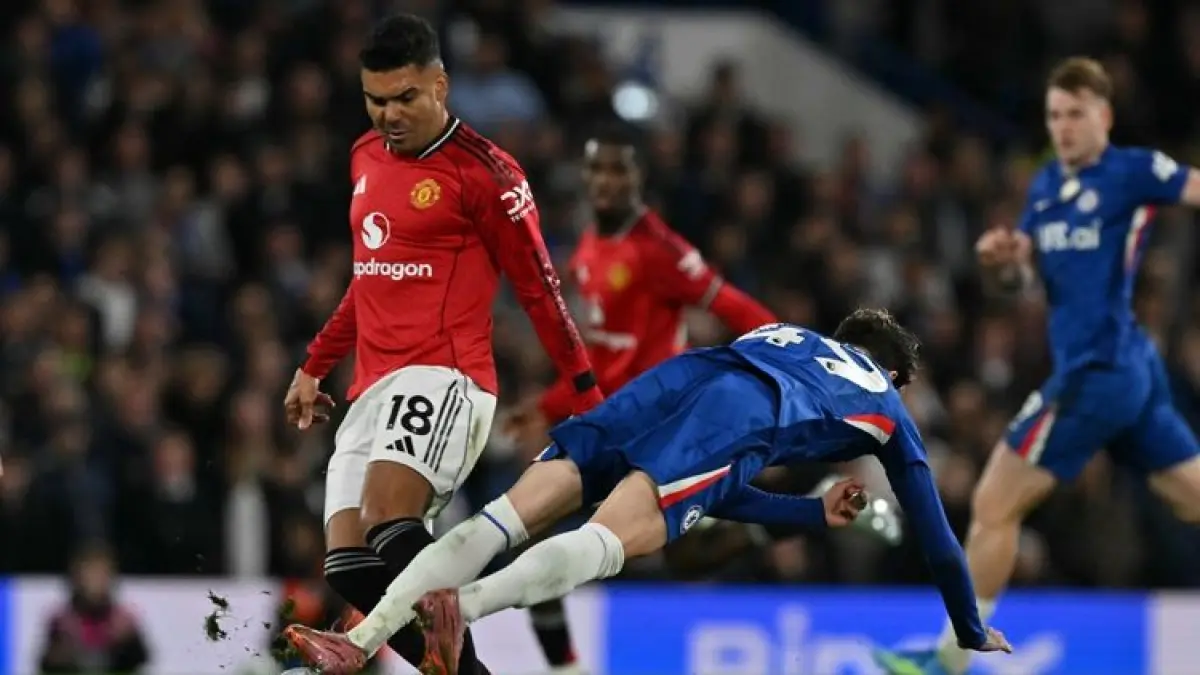 BERDUEL: Gelandang Manchester United, Casemiro (kiri) berduel dengan pemain Chelsea, Alejandro Garnacho (kanan) dalam pertandingan sepak bola Liga Inggris di Stamford Bridge, Minggu (19/4).
(AFP/GLYN KIRK)