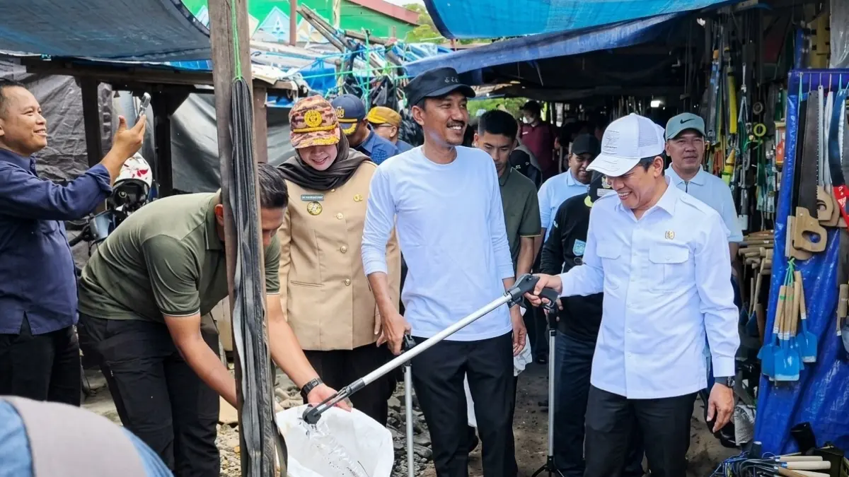 JEPIT: Menteri Lingkungan Hidup RI Hanif Faisol Nurofiq memungut sampah saat aksi bersih-bersih di kawasan Pasar Batuah Martapura, Kabupaten Banjar, Senin (20/4) sore. (FADLAN ZAKIRI/RADAR BANJARMASIN)