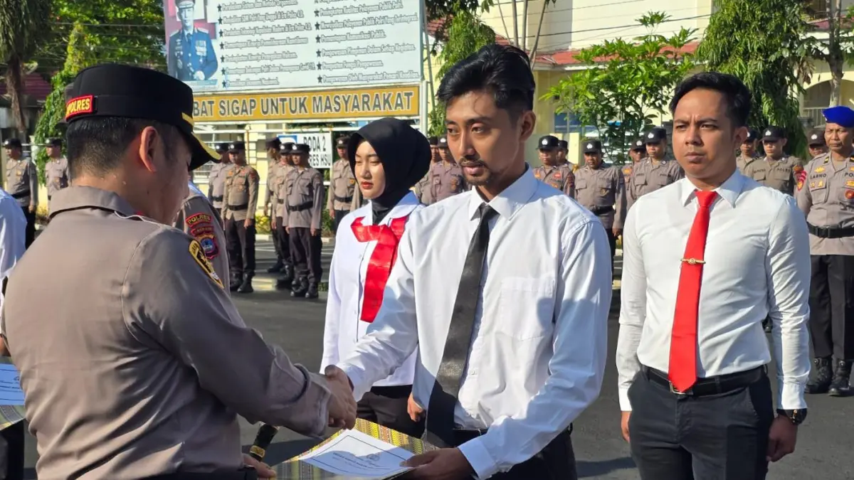 MOMEN: Kapolres HSU AKBP Agus Nuryanto menyerahkan penghargaan kepada personel berprestasi saat apel di Lapangan Polres Hulu Sungai Utara, Selasa (21/4). (Foto: Polres HSU)