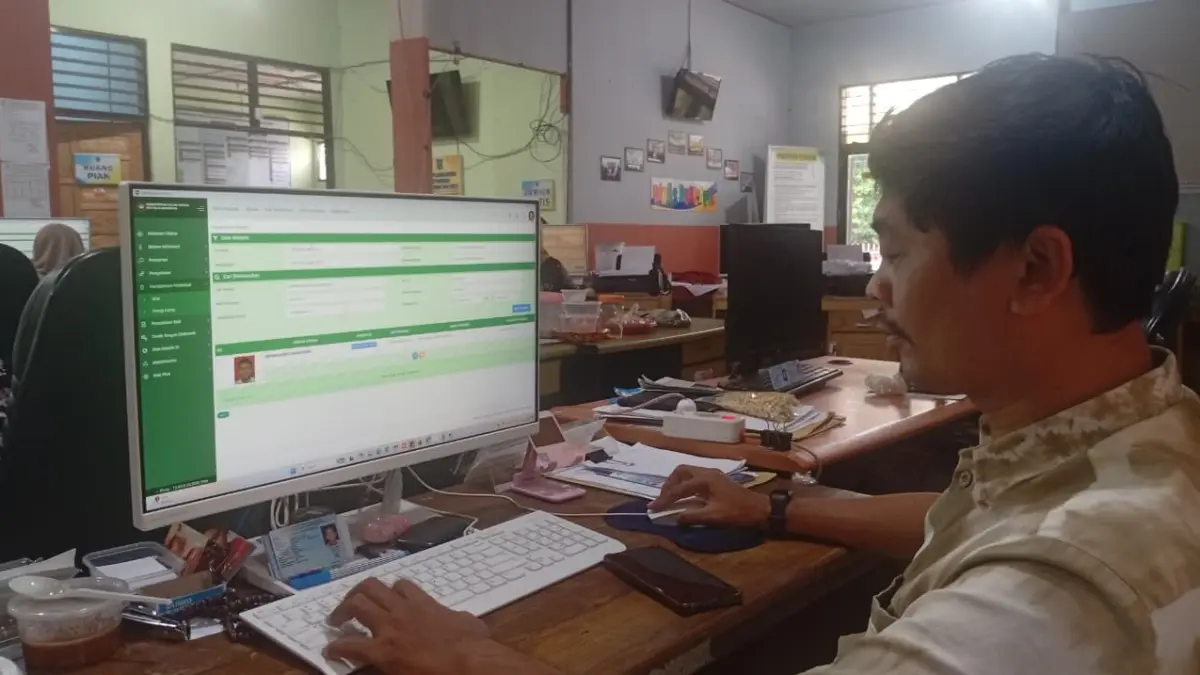 DATA: Operator SIAK Haris Fadillah saat menunjukkan data kedatangan penduduk baru di HSS.
