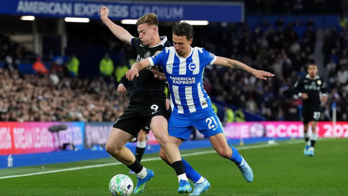 MEREBUT: Pemain Brighton, Olivier Boscagli (kanan) mencoba merebut bola dari kaki penyerang Chelsea, Liam Delap dalam pertandingan Liga Inggris, Rabu (22/4).&nbsp;
(AFP)&nbsp;
