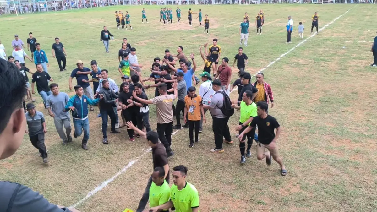 RICUH: Suasana kericuhan saat sejumlah penonton memasuki lapangan di tengah laga final Bupati Cup antara Batumandi dan Lampihong yang berakhir dengan skor 1-0. (Foto: M Dirga / Radar Banjarmasin)