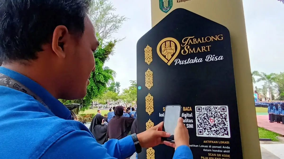 TUGU BACA DIGITAL : Seorang warga Tabalong melakukan scand barcode ke tugu baca digital milik Dispersip Tabalong. (Foto : Ibnu Dwi Wahyudi/ Radar Banjarmasin)