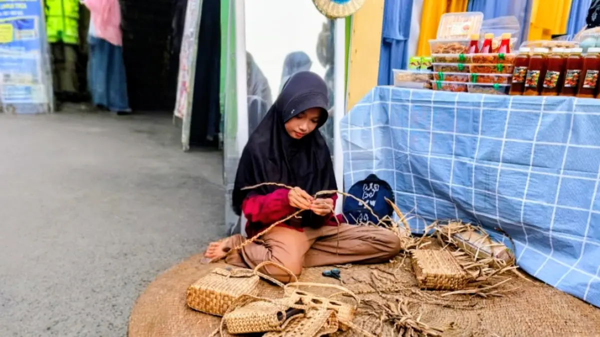 CARI CUAN:Syakira Nur Afifah (12), siswi kelas 5 SD di kabupaten HSU menganyam eceng gondok menjadi tas untuk dijual di stand pameran Apindo Expo Amuntai.(Foto:Istimewa)