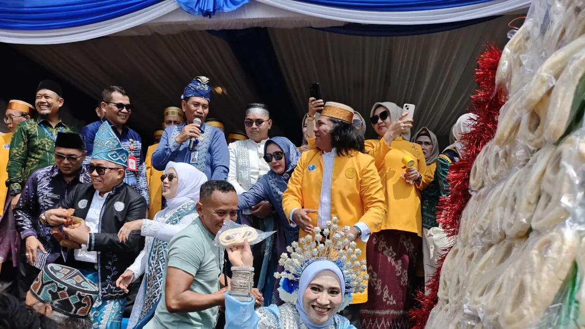 KANREJAWA PUTE: Sekda Tanah Bumbu Yulian Herawati melempar kue tradisional kepada warga dalam rangkaian Mappanre Ri Tasi’e di Pantai Pagatan, Ahad (26/4). (Foto: Zulqarnain/Radar Banjarmasin)
