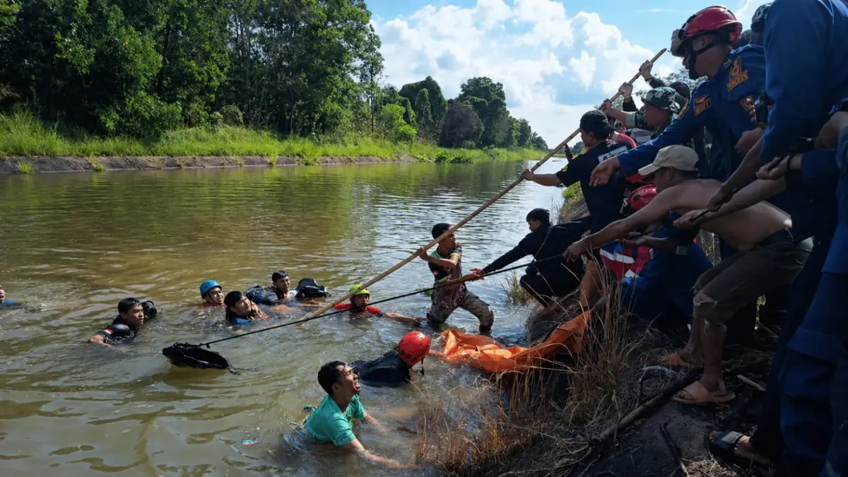 EVAKUASI: Petugas DPKP Kabupaten Banjar bersama relawan mengevakuasi korban tenggelam di saluran irigasi Desa Tungkaran, Kecamatan Martapura, Selasa (28/4) sore. (Foto: DPKP Kabupaten Banjar)
