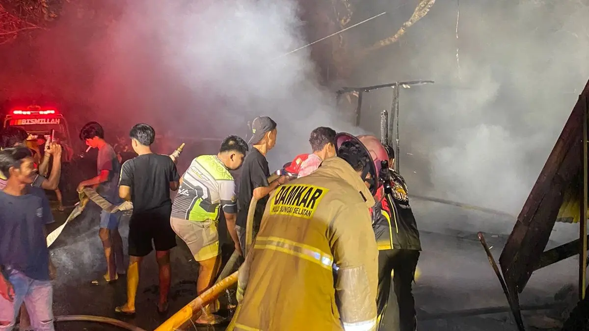 Petugas pemadam kebakaran memadamkan api yang menghanguskan rumah warga di Sungai Kupang. (DAMKAR HSS)