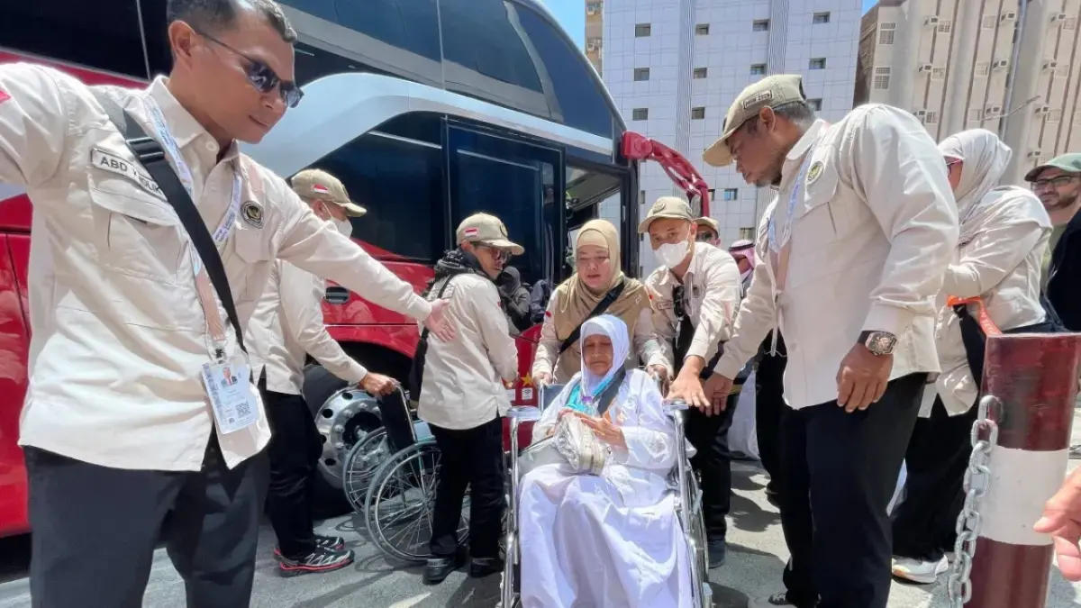 LAYANAN HAJI: Petugas PPIH Arab Saudi membantu jemaah haji lansia turun dari bus menggunakan kursi roda saat tiba di Makkah, Kamis (30/4). (Kemenhaj)