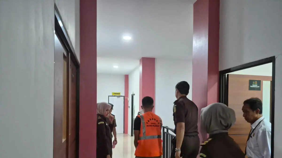 TERSANGKA BARU:Pegawai Dinas Kesehatan Kabupaten Tanah Laut (Dinkes Tala) berinisia K saat digiring ke mobil tahanan oleh petugas Kejari Tala usai ditetapkan sebagai tersangka kasus tipikor dana BOK tahun anggaran 2019-2020 pada Puskesmas Angsau, Selasa (5/5/2026) sore.(Foto : Norsalim Yahya/Radar Banjarmasin)