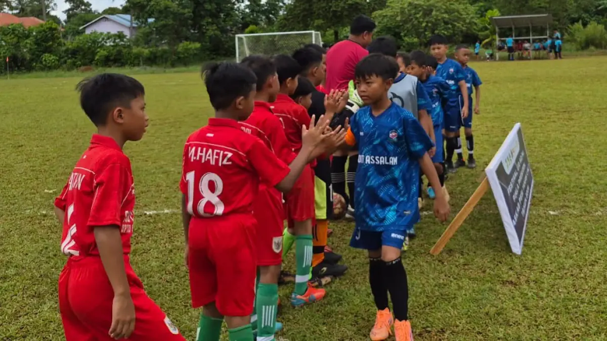 DIMULAI: Tim dari SD Assalam (jersey biru) melakukan tos dengan tim lawan sebelum bertanding dalam Turnamen Piala Presiden U-10 dan U-12 tahun 2026 di Lapangan Sepak Bola Pinang Babaris, Kelurahan Pabahanan, Pelaihari.