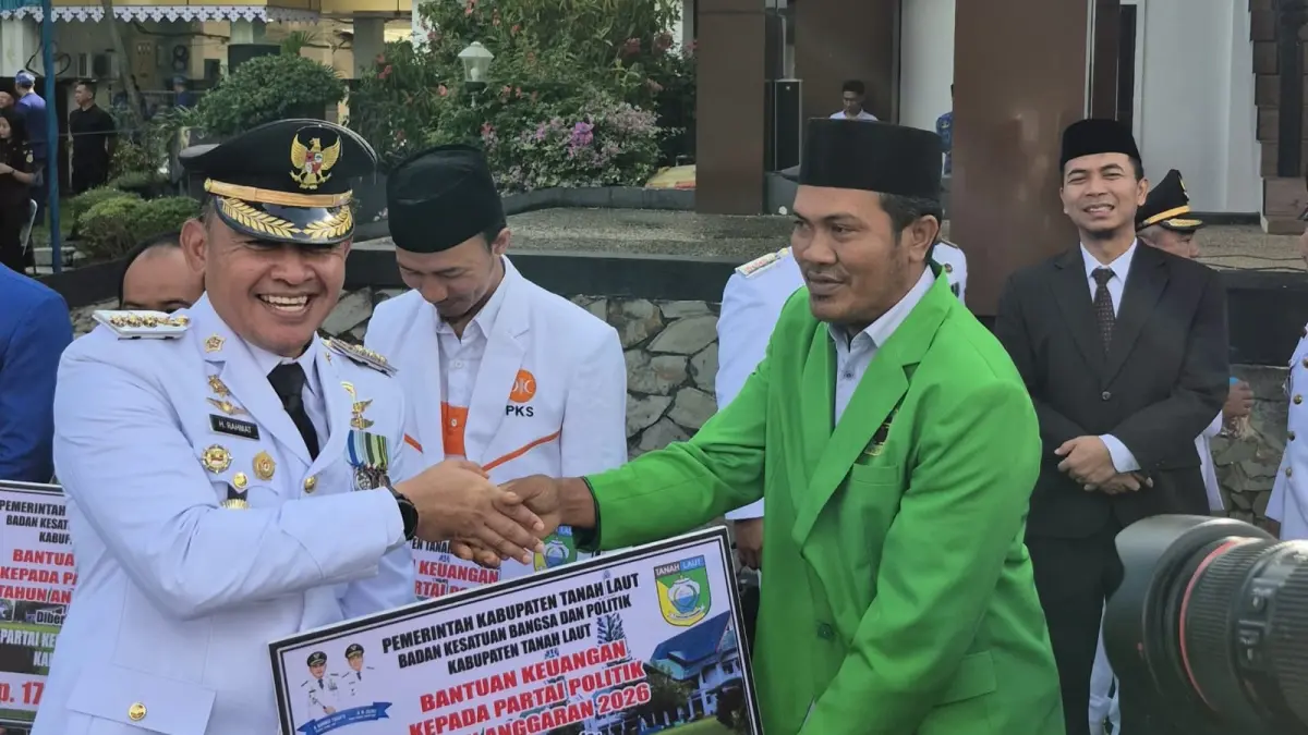 SIMBOLIS: Bupati Tala H Rahmat Trianto (kiri) menyerahkan bantuan parpol kepada perwakilan sembilan parpol di Tala. (Foto : Jali untuk Radar Banjarmasin)