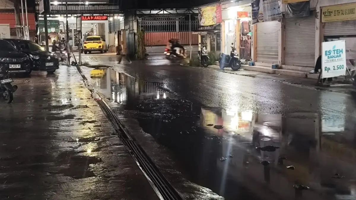 BANYAK JEBAKAN: Kondisi jalan berlubang yang tertutup genangan air di kawasan Malkon Temon, Banjarmasin Utara. DPRD mendorong perbaikan permanen karena dinilai membahayakan pengendara. (Foto: Arul untuk Radar Banjarmasin)