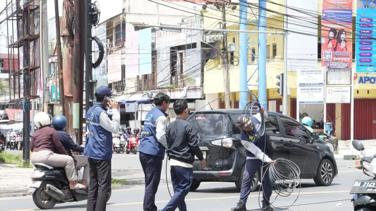 Petugas Dishub Banjarmasin merapikan kabel fiber optik yang menjuntai di kawasan Jalan S. Parman, Selasa (5/5). (Yayan)