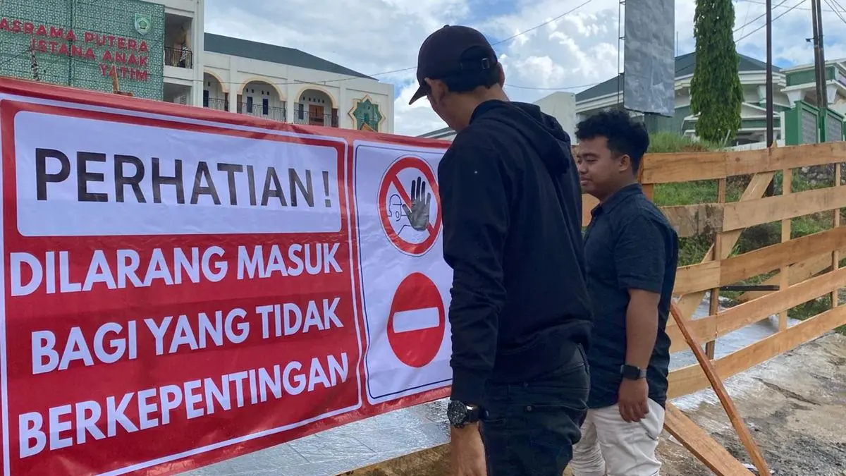 DILARANG MASUK: Petugas Dinas PUPRPerkim Kabupaten Balangan memasang pagar penghalang di akses utama bangunan Istana Anak Yatim guna mencegah masuknya pihak luar yang tidak berkepentingan. (Foto: Dinas PUPRPerkim Kabupaten Balangan)