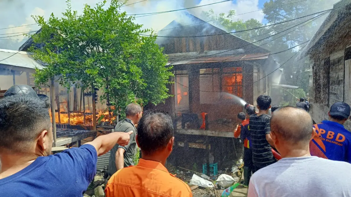 JADI ARANG: Petugas BPBD Balangan bersama relawan menyiram air ke rumah warga yang terbakar di Desa Muara Ninian, Kecamatan Juai, Balangan.