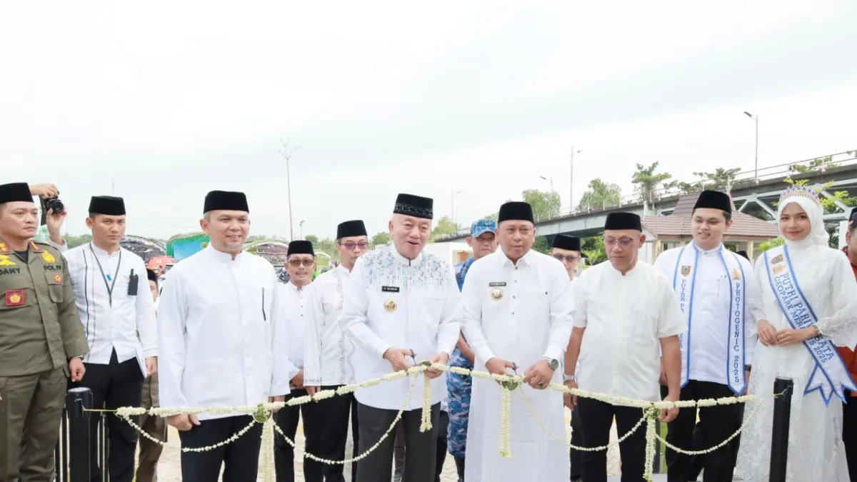 PERESMIAN – Gubernur Kalsel H Muhidin didampingi Bupati Barito Kuala H Bahrul Ilmi memotong pita untaian bunga melati sebagai tanda diresmikannya kawasan wisata bawah Jembatan Barito.