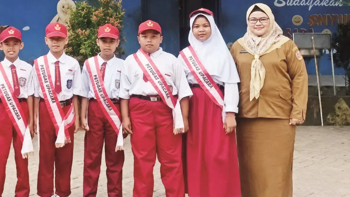 BERSAMA: Guru SDN 2 Bangkal, Kecamatan Cempaka, Kota Banjarbaru, Renny Purwasari saat bersama murid.&nbsp;
(Foto: FADLAN ZAKIRI/RADAR BANJARMASIN)