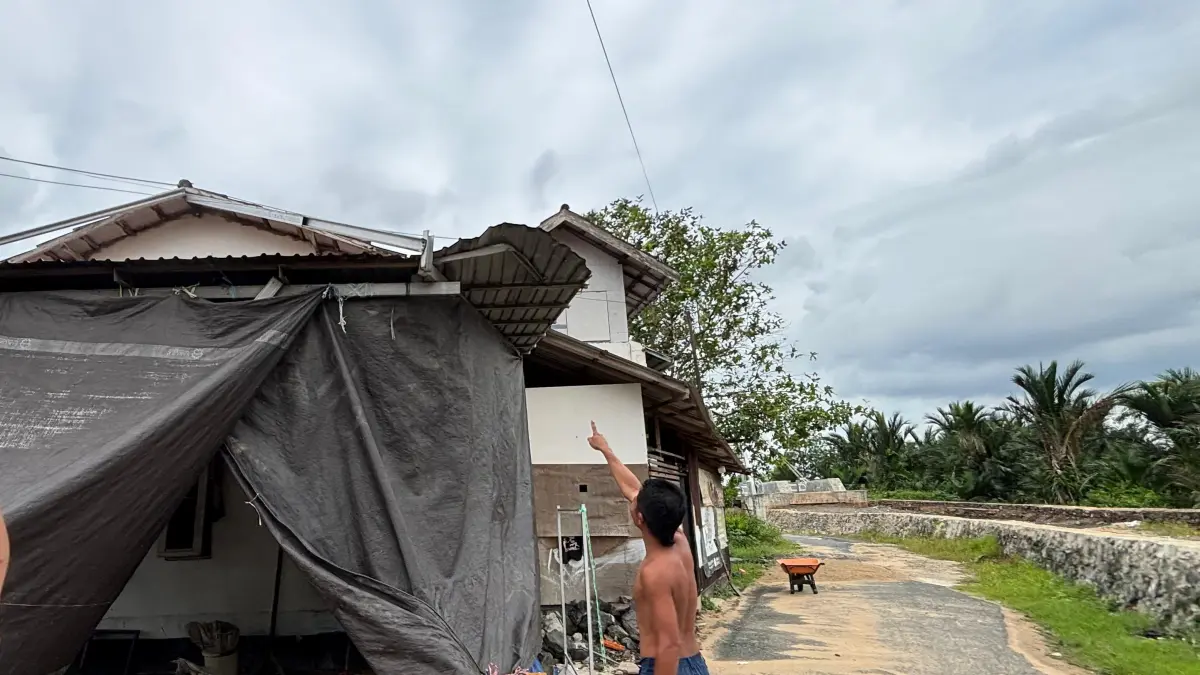 MENUNJUKKAN: Aulia, warga Sungai Andai Banjarmasin yang tinggal dekat dengan proyek Jembatan Cusa menunjukkan bagian atap akibat terkena truk molen. (Zulvan Rahmatan/Radar Banjarmasin)