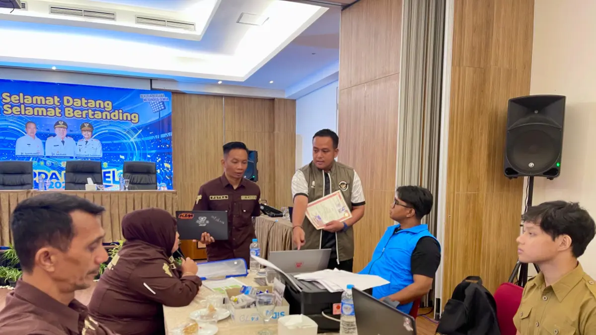 PENGECEKAN: Petugas Dispora Kalsel melakukan pengecekan dokumen atlet dalam proses verifikasi keabsahan peserta POPDA di Banjarmasin, Senin (12/5/2026). (M Idris Jian Sidik)
