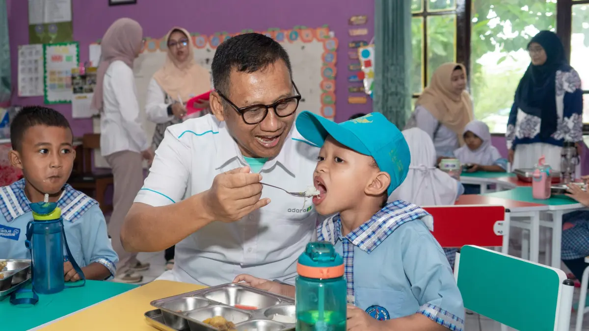 LAHAP: Seorang anak TK Negeri Pembina Paringin menikmati suapan makanan dari Presiden Direktur PT Adaro Indonesia, Priyadi.