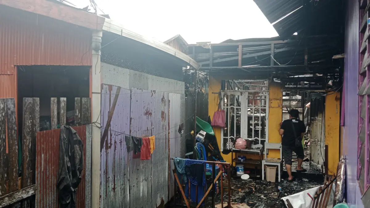 SISAKAN PUING: Pihak keluarga korban mengecek kondisi bangunan rumah yang terbakar.
