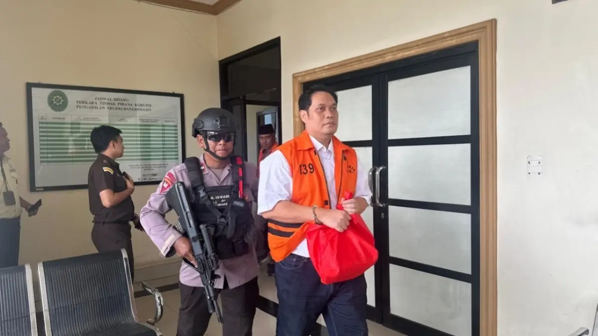 TANGAN TERBORGOL: Mantan Kajari Hulu Sungai Utara, Albertinus Parlinggoman Napitupulu dikawal Anggota Brimob menuju mobil tahanan usai menjalani sidang dakwaan di PN TIpikor Banjarmasin, Selasa (12/5). (Muhammad Oscar Fraby)