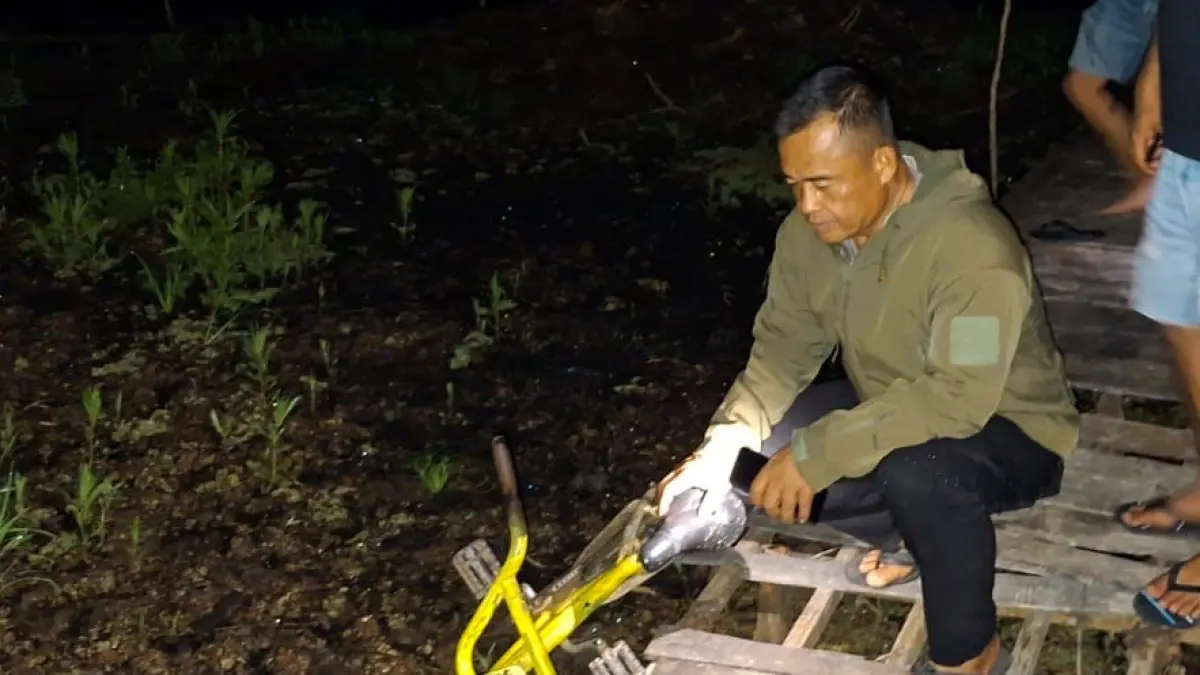 IDENTIFIKASI : Anggota polisi saat menunjukkan sepeda milik korban yang dibawa mancing.