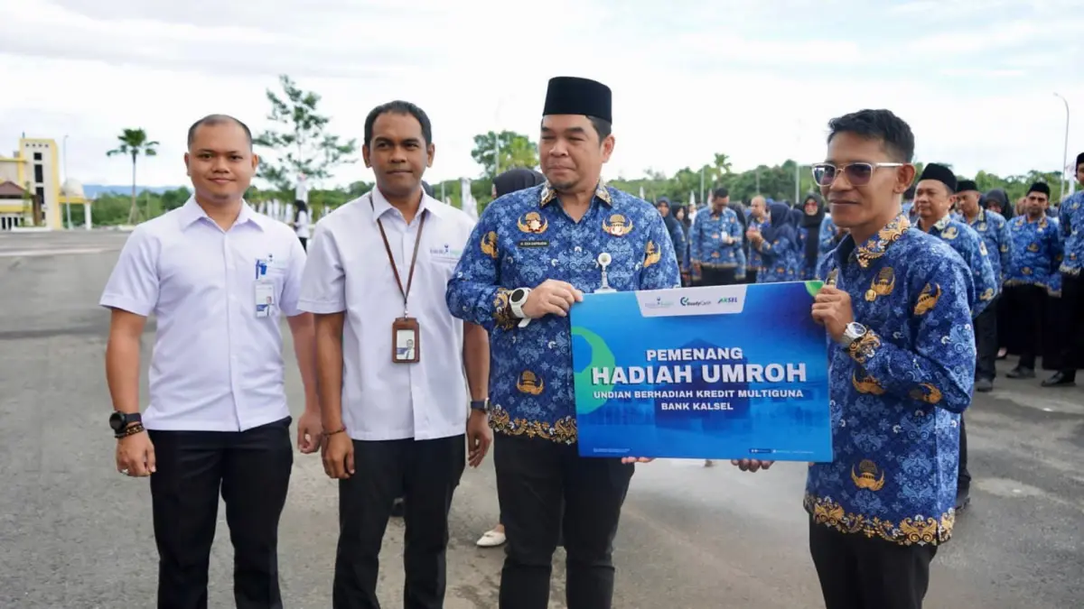SENANG: Sekda Kabupaten Kotabaru, Eka Saprudin bersama perwakilan Bank Kalsel Kotabaru menyerahkan hadiah kepada umrah kepada salah satu ASN yang beruntung jadi pemenang program undian Kredit Multiguna Bank Kalsel, Senin (18/5/2026).(Foto:Prokopim Setda Kotabaru)