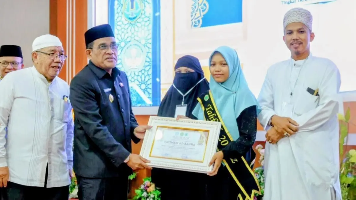 PRESTASI: Bupati HSU Sahrujani menyerahkan piagam penghargaan kepada wisudawati terbaik pada Wisuda Tahfiz SD dan SMP se-Kabupaten HSU di Gedung Abdul Wahid Amuntai.