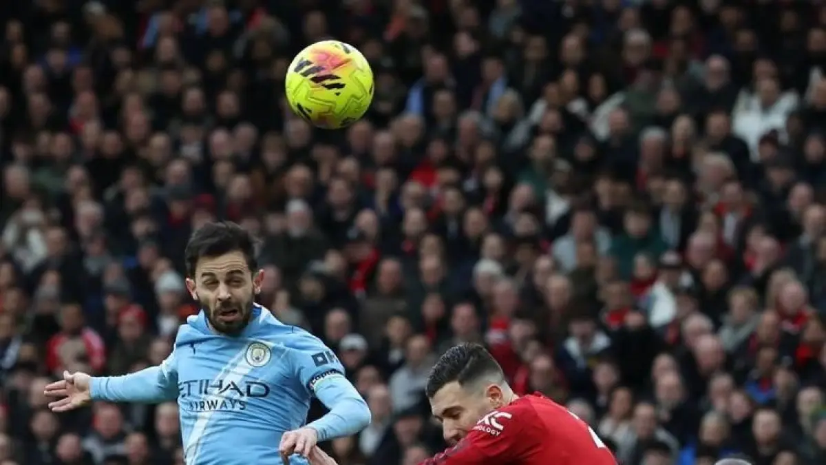 BERDUEL: Bernardo Silva berduel udara dengan Diogo Dalot dalam pertandingan sepak bola Liga Inggris Manchester United vs Manchester City.
(Darren Staples / AFP)