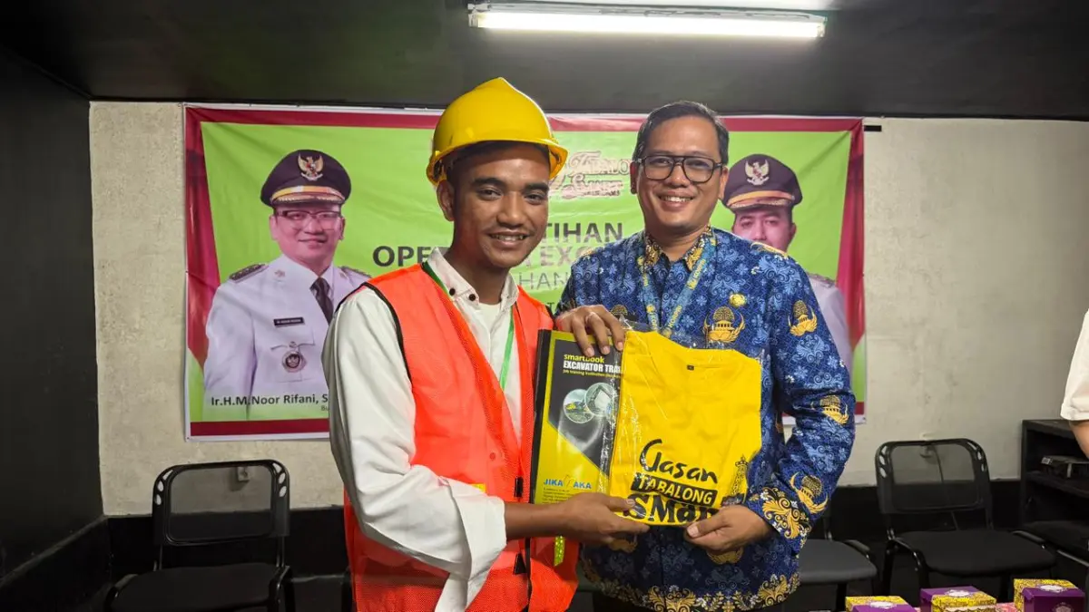 SEMANGAT:&nbsp; Lurah Agung, Kabupaten Tabalong, Riski Maulana menyerahkan seragam pelatihan alat berat kepada salah seorang peserta.(Foto:Kelurahan Agung)