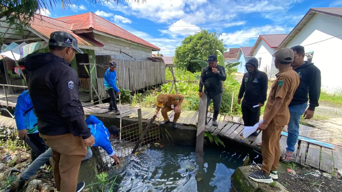 DRAINASE: Petugas Disperkimtan Tanah Bumbu meninjau dan membersihkan saluran drainase di kawasan permukiman untuk mengatasi genangan air saat musim hujan. (Foto: Disperkimtan Tanah Bumbu untuk Radar Banjarmasin)