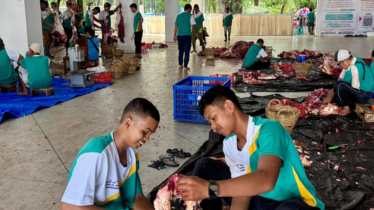 Dua orang pelajar tampak terlibat sebagai panitia kurban di Masjid Al Jihad Banjarmasin. Keterlibatan generasi muda ini ditargetkan menjadi bagian dari budaya regenerasi di lingkungan masjid. (Zulvan Rahmatan/Radar Banjarmasin).