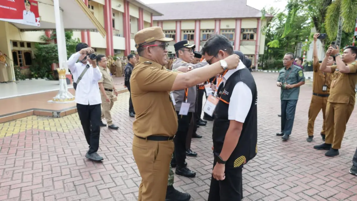 MOMEN: Bupati HSU, H Sahrujani memasang tanda pengenal petugas lapangan Sensus Ekonomi 2026 di halaman Kantor Bupati HSU, Selasa (2/6/2026). (Foto: Pemkab HSU)
